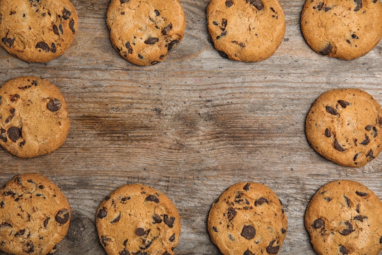 Photo of Delicious chocolate chip cookies on wooden table, flat lay. Space for text