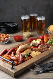 Set of different tasty snacks and beer on wooden table
