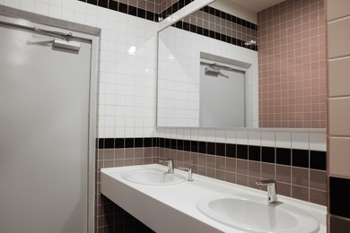 Public toilet interior with sinks and mirror
