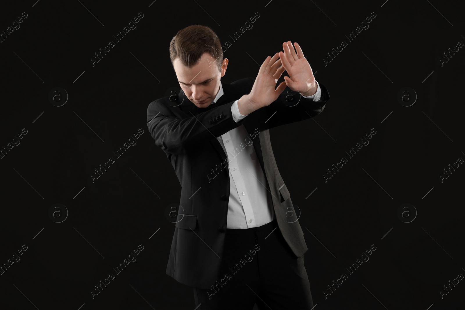 Photo of Man covering face with hands on black background