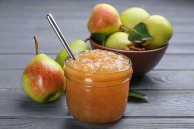 Delicious pear jam and fresh fruits on grey wooden table