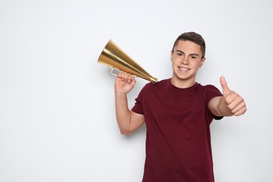 Photo of Teenage boy with megaphone on white background. Space for text