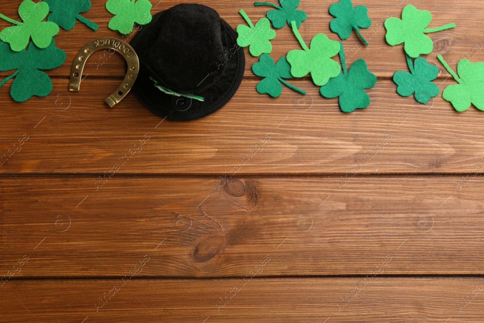 Photo of Flat lay composition with leprechaun hat on wooden table, space for text. St Patrick's Day celebration