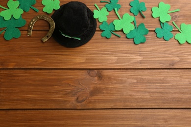 Flat lay composition with leprechaun hat on wooden table, space for text. St Patrick's Day celebration