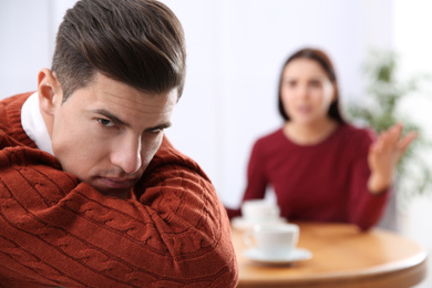 Photo of Unhappy man after quarrel with his girlfriend indoors. Relationship problems