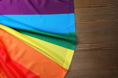 Rainbow gay flag on wooden background, top view with space for text. LGBT concept