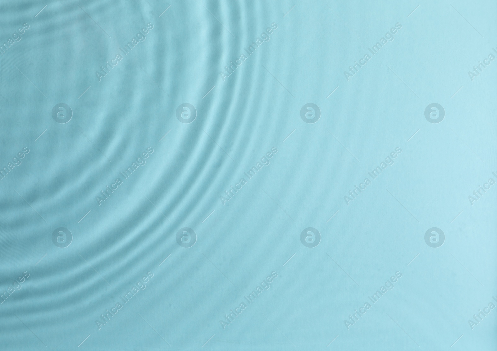 Photo of Closeup view of water with circles on turquoise background. Space for text