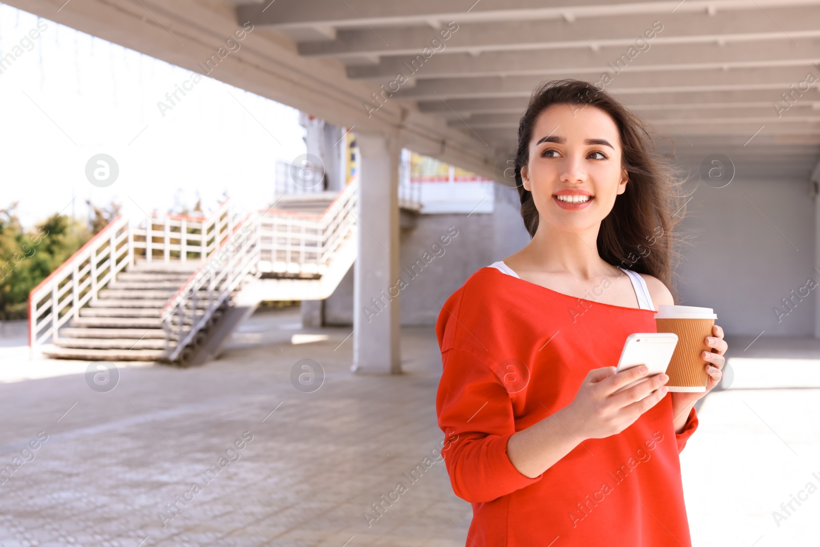 Photo of Young woman using mobile phone outdoors