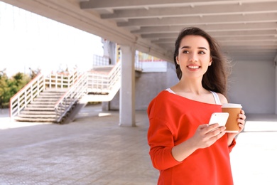 Photo of Young woman using mobile phone outdoors