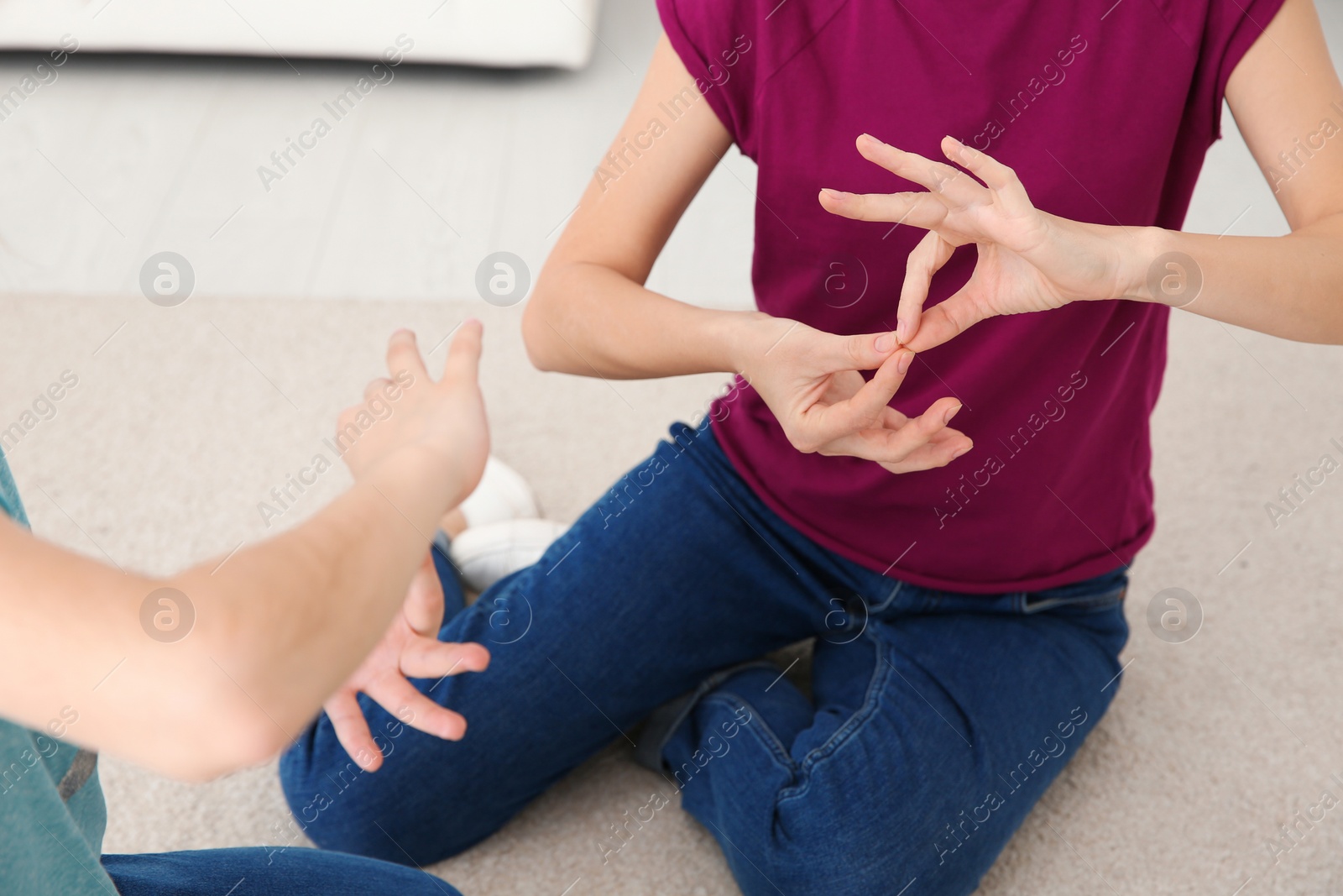 Photo of Hearing impaired mother and her child talking with help of sign language indoors, closeup