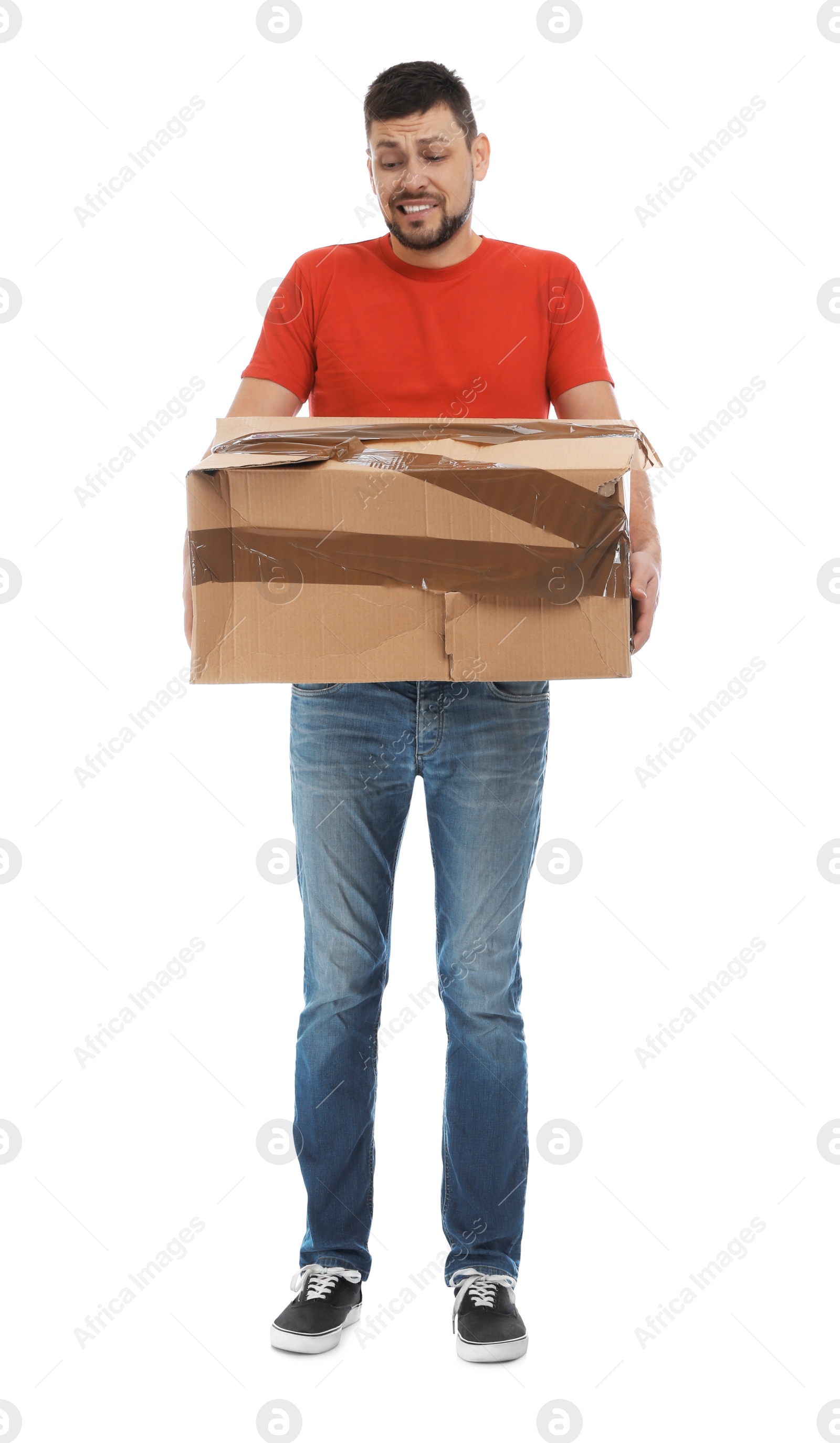 Photo of Emotional courier with damaged cardboard box on white background. Poor quality delivery service