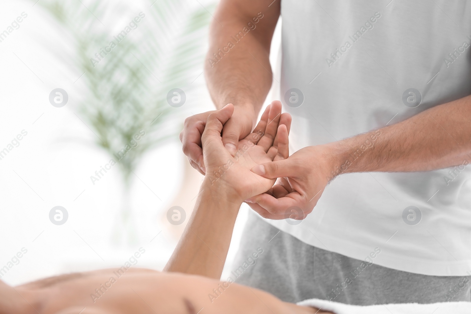 Photo of Young man receiving massage in salon, closeup