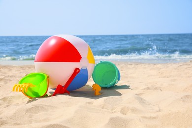 Photo of Different sand toys and beach ball near sea, space for text