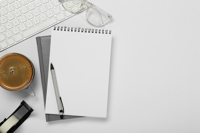 Photo of Flat lay composition with notebooks and coffee on white table. Space for text