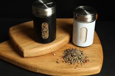 Photo of Salt and pepper shakers on black table