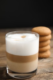Photo of Delicious latte macchiato and cookies on wooden table