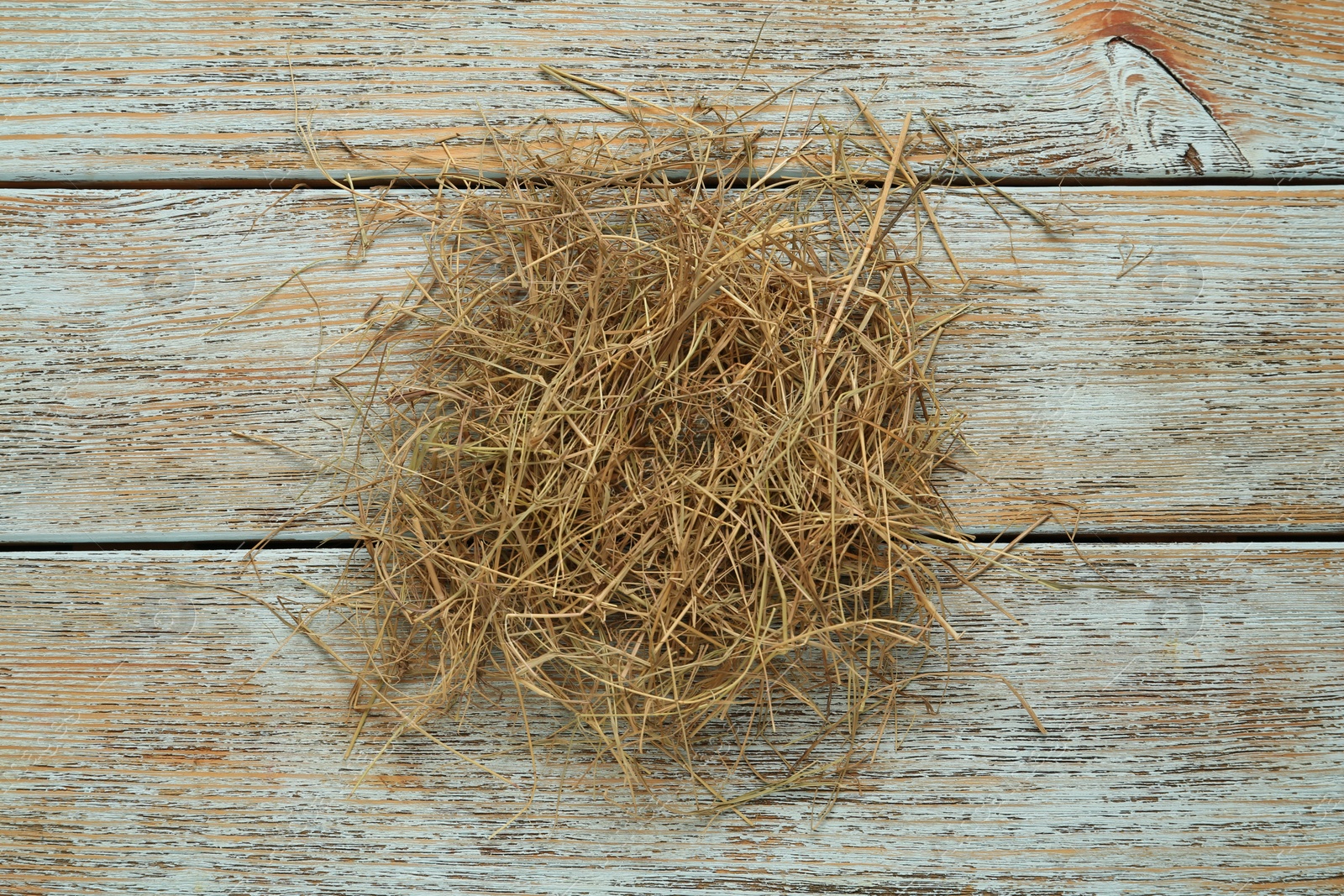 Photo of Heap of dried hay on light wooden background, flat lay