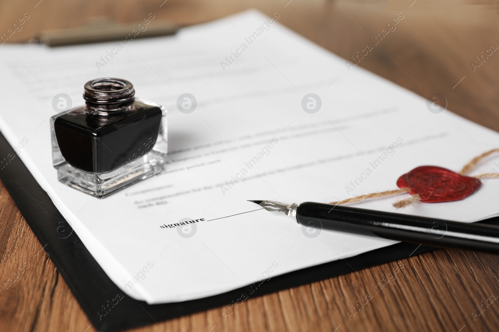 Photo of Document, fountain pen and inkwell on wooden table, closeup. Notary contract