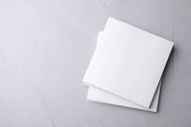 Photo of Blank note papers on light grey background, top view. Mock up for design