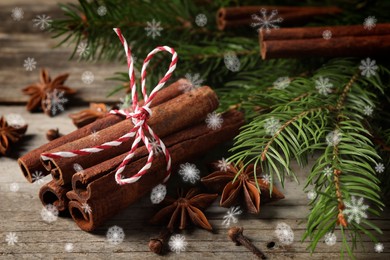 Different spices and fir tree branches on wooden table, closeup. Cinnamon, anise, cloves