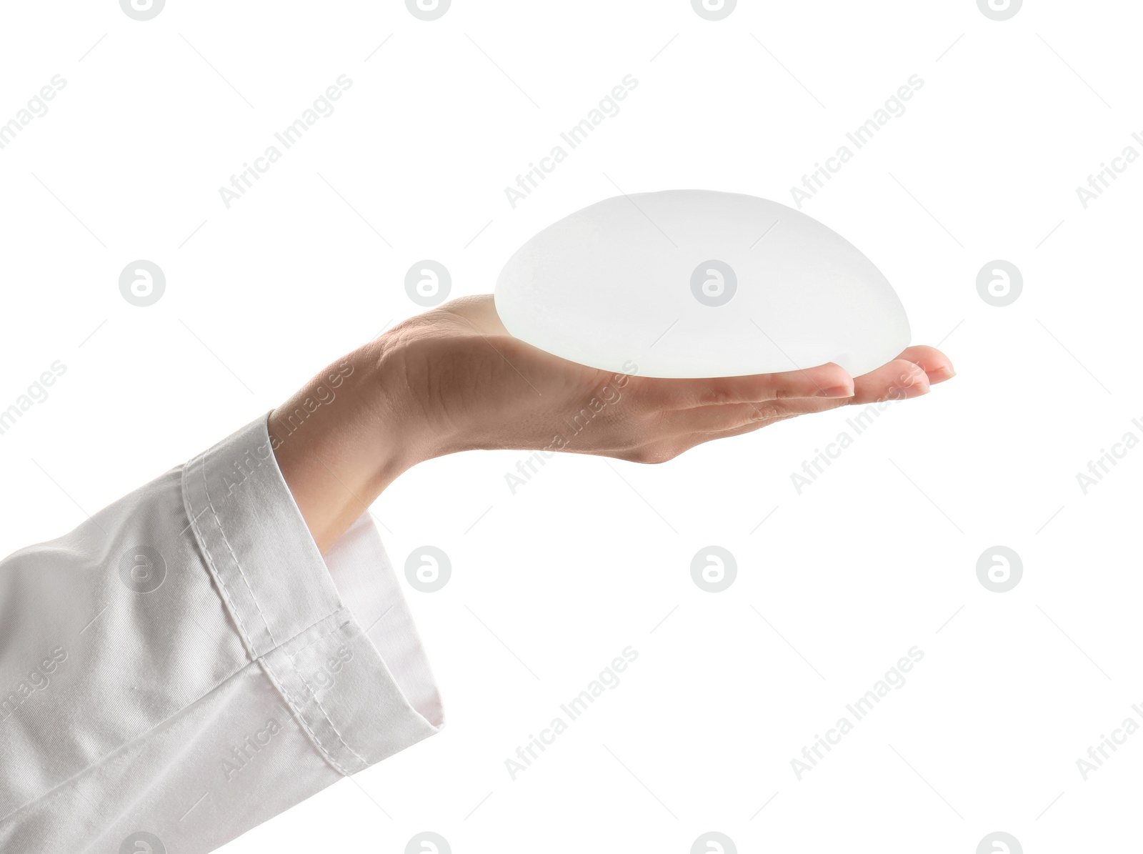 Photo of Doctor holding silicone implant for breast augmentation on white background. Cosmetic surgery