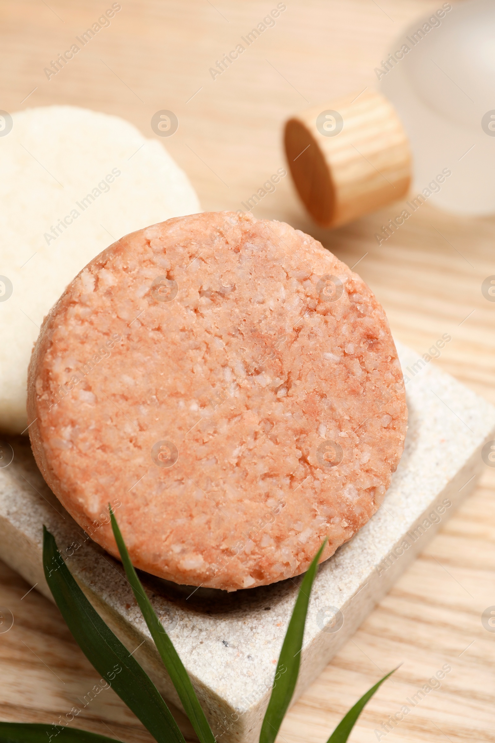 Photo of Dish with solid shampoo bars on wooden table, closeup