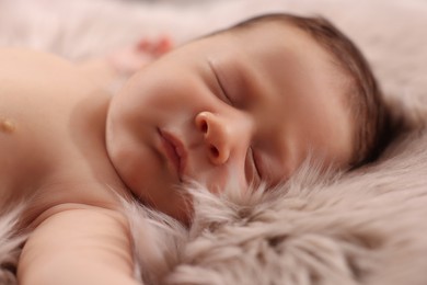 Cute newborn baby sleeping on fluffy blanket, closeup