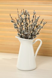 Photo of Beautiful pussy willow branches in vase on white table