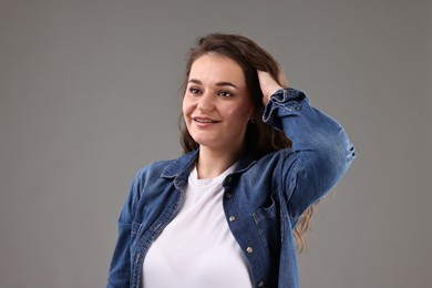 Portrait of beautiful young woman on grey background