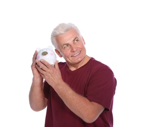 Mature man with piggy bank on white background