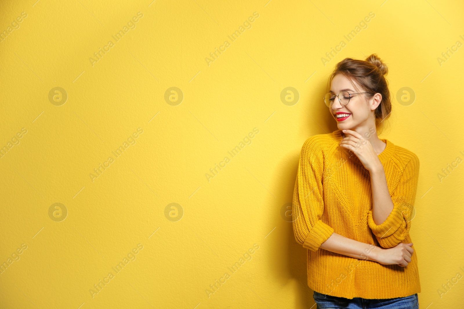 Photo of Beautiful young woman in warm sweater on color background. Space for text