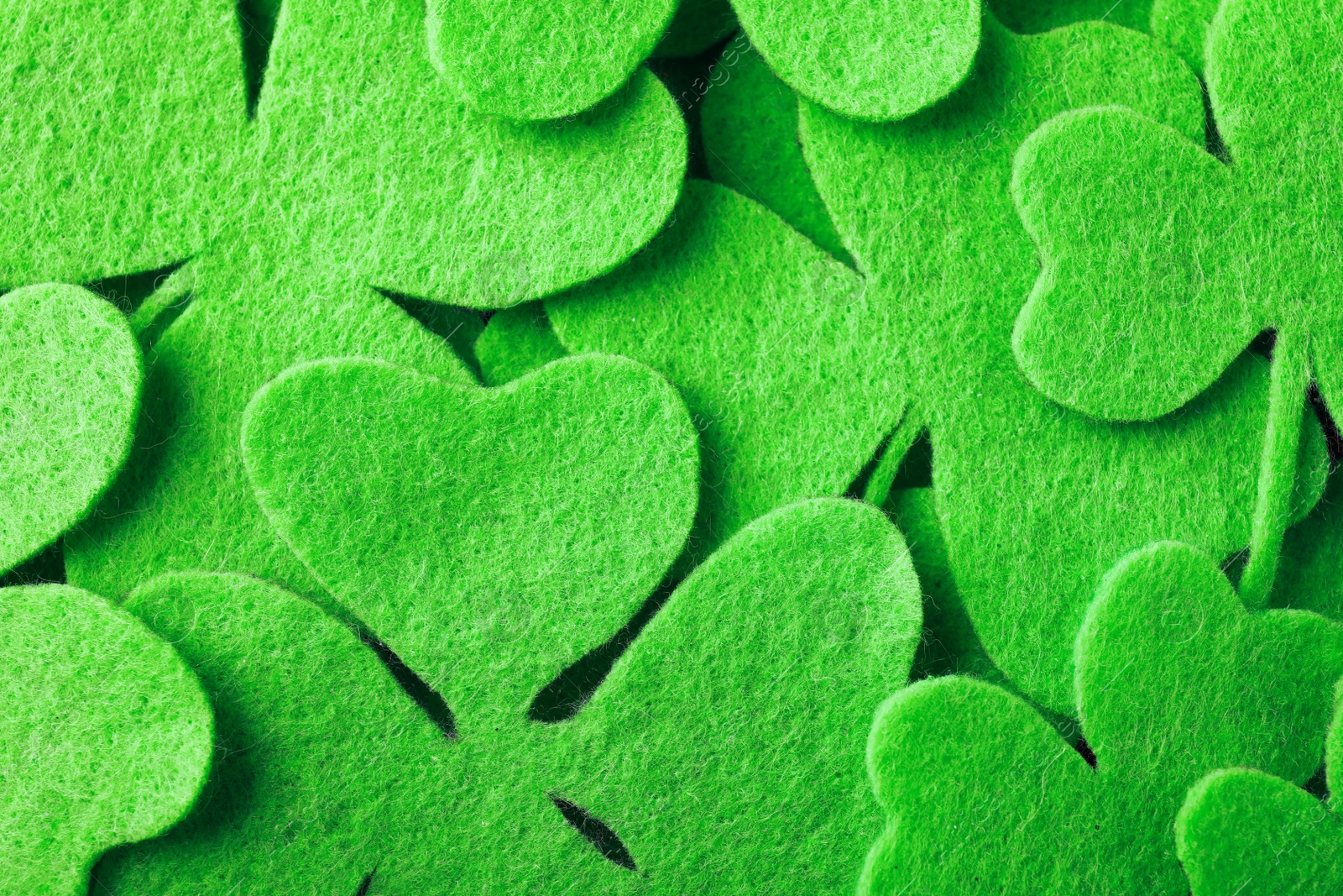 Photo of Green clover leaves as background, top view. St. Patrick's Day celebration