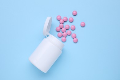 Photo of Bottle and antidepressant pills on light blue background, flat lay
