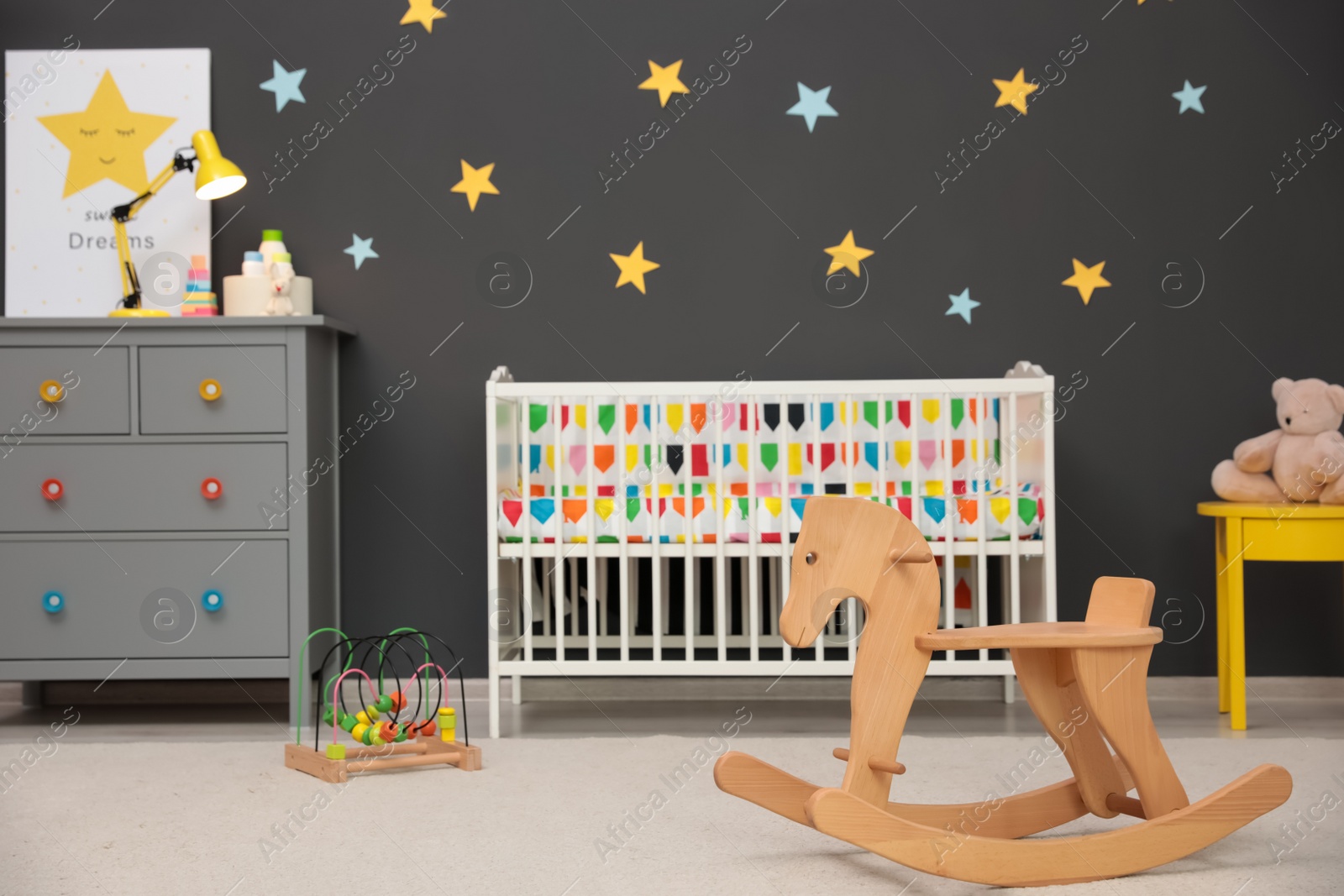 Photo of Cute baby room interior with modern crib and rocking horse