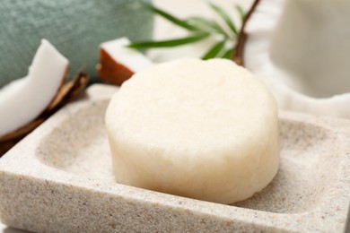 Photo of Solid shampoo bar in stone holder, closeup. Hair care