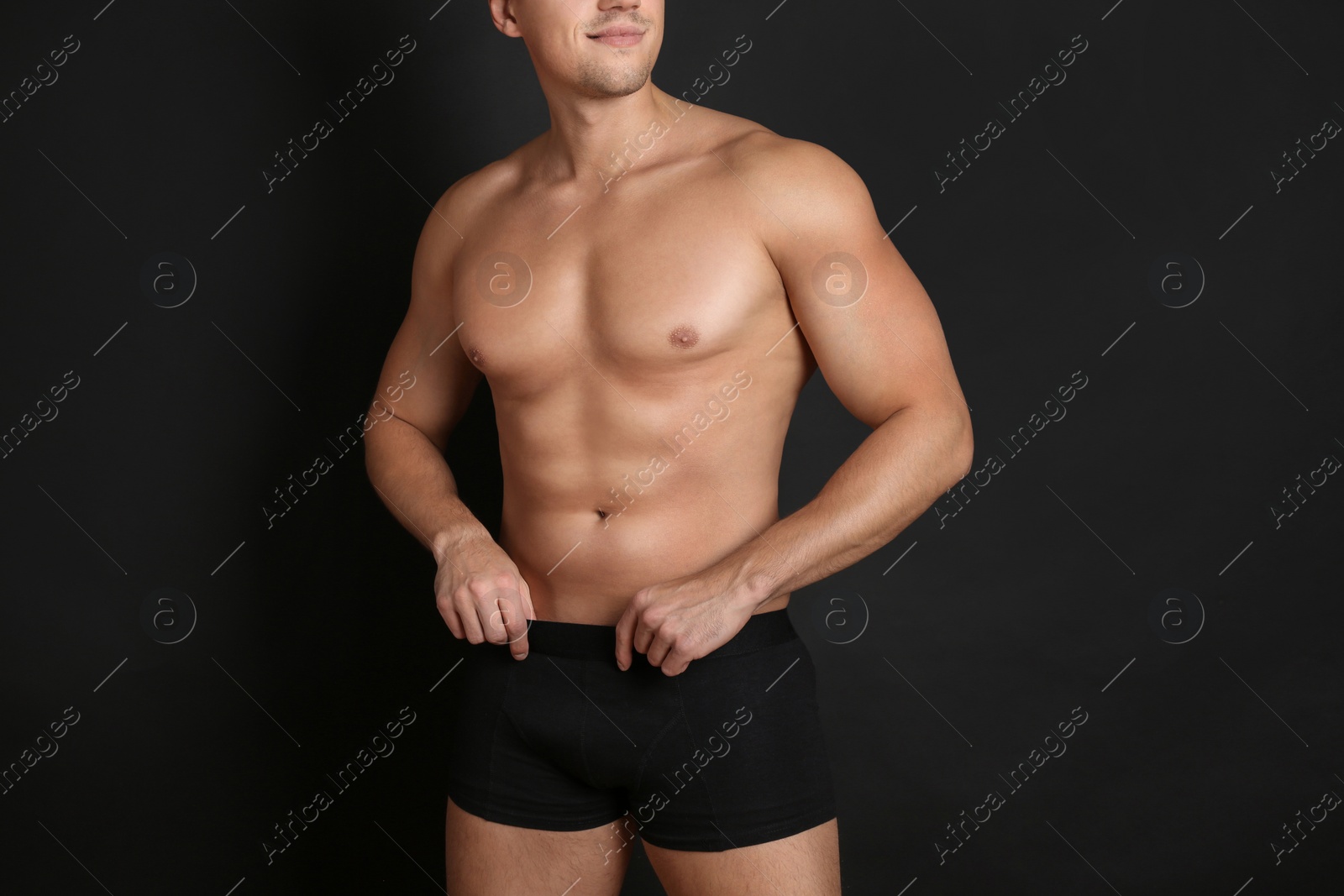 Photo of Man with sexy body on black background, closeup