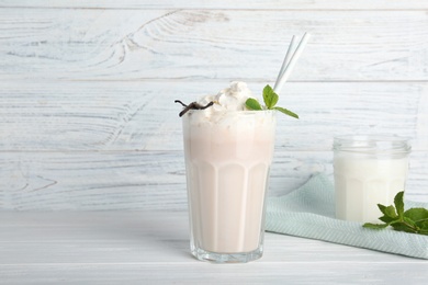 Photo of Glassware with delicious milk shakes on table