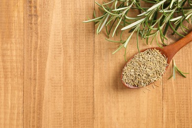 Fresh and dry rosemary on wooden table, flat lay. Space for text