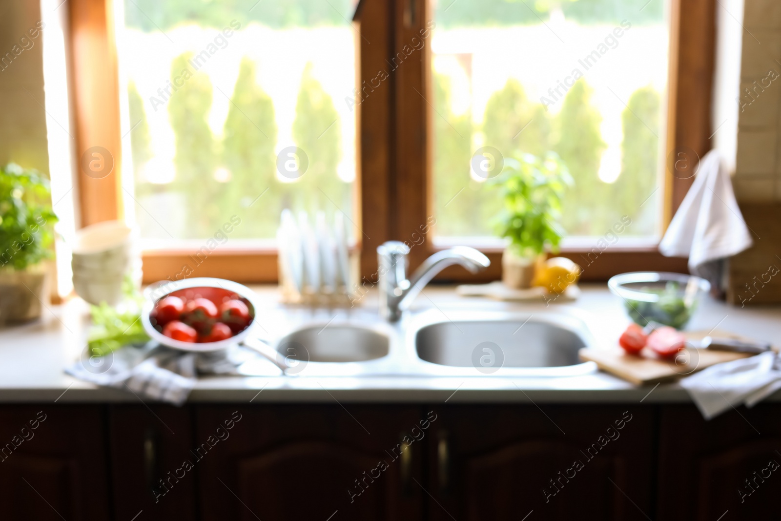 Photo of Blurred view of stylish kitchen interior with sink and products