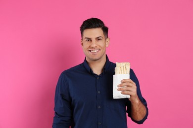 Photo of Man with delicious shawarma on pink background