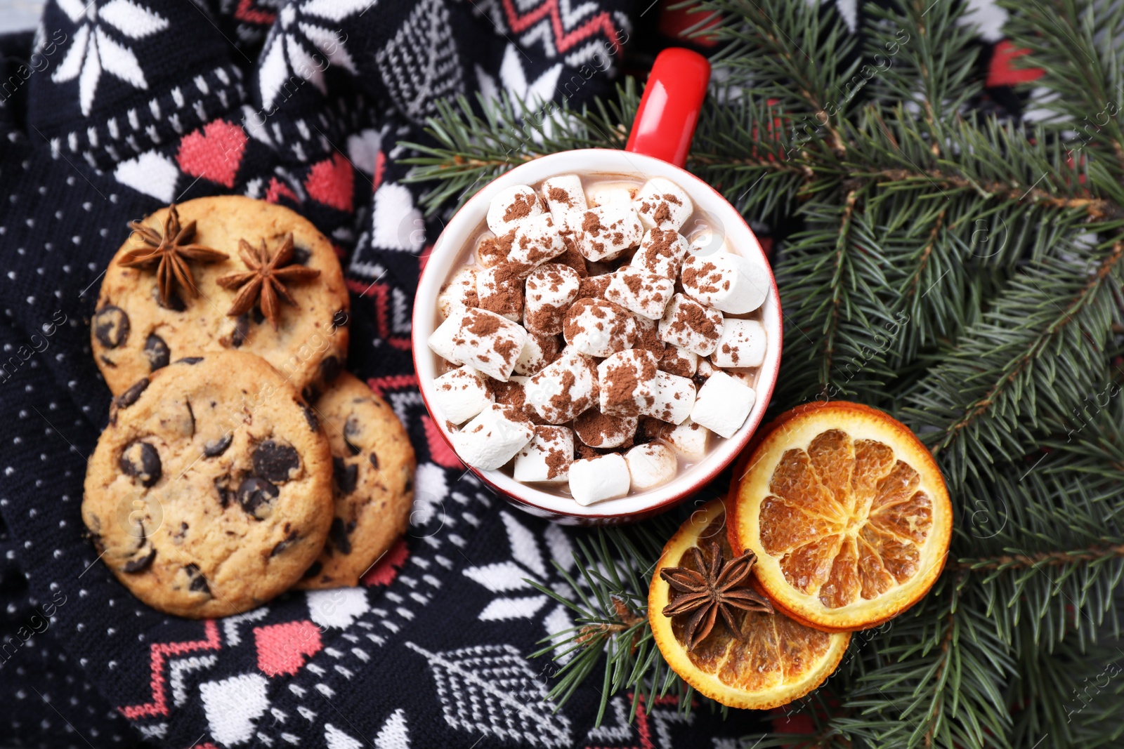 Photo of Cup of tasty cocoa with marshmallows on knitted cloth, flat lay