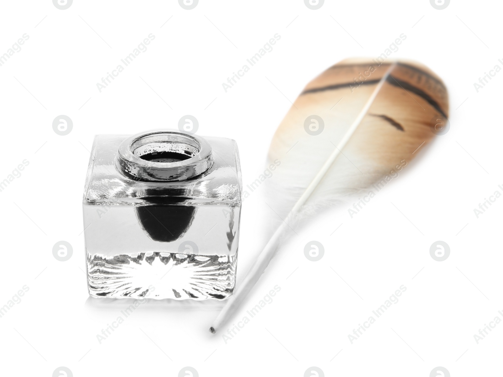 Photo of Feather pen and inkwell on white background