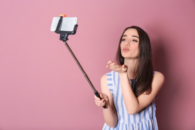 Photo of Young beautiful woman taking selfie against color background