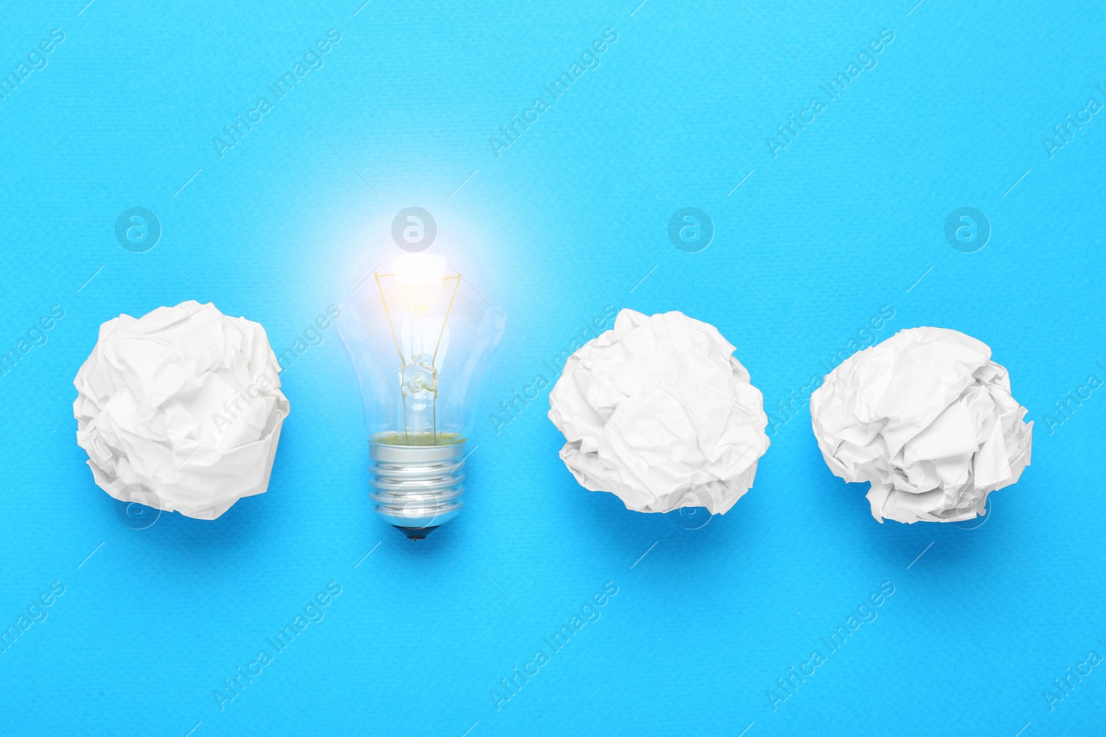 Photo of Creative flat lay composition with lightbulb and paper balls on light blue background. Idea concept