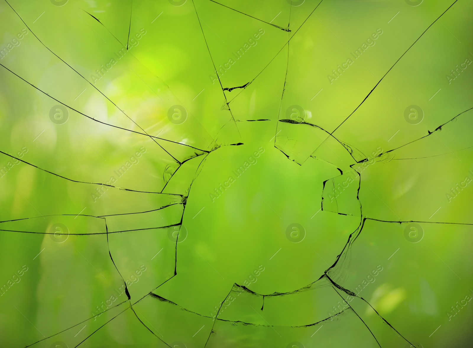 Image of View through broken window on blurred green background