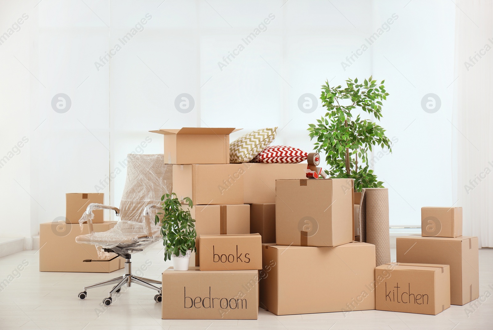 Photo of Pile of moving boxes in empty room