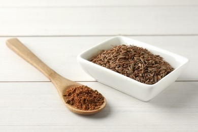 Photo of Caraway (Persian cumin) seeds and powder on white wooden table