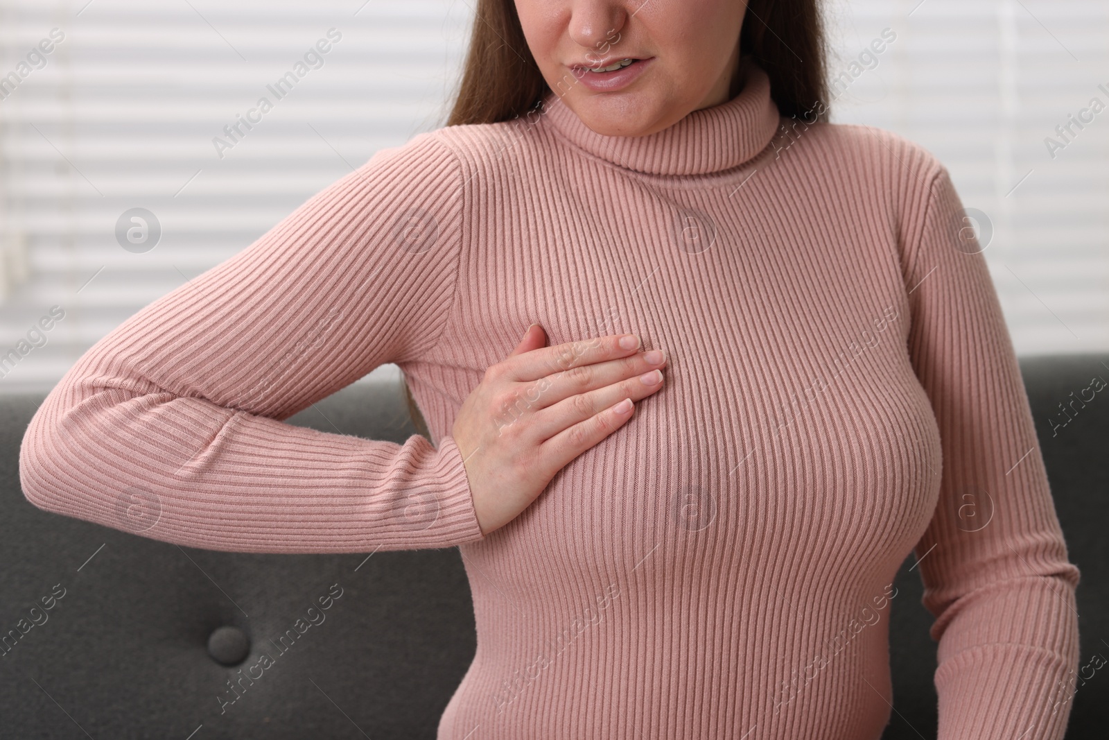 Photo of Mammology. Woman doing breast self-examination indoors, closeup