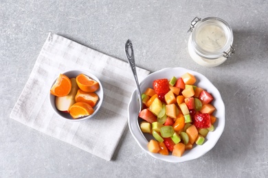 Photo of Bowl with fresh fruit salad on grey background