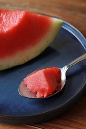 Sliced fresh juicy watermelon and spoon on wooden table, closeup